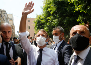 French President Emmanuel Macron gestures towards residents as he visits a devastated street of Beirut, Lebanon, on August 6, 2020 a day after a massive explosion devastated the Lebanese capital in a disaster that has sparked grief and fury. - French President Emmanuel Macron visited shell-shocked Beirut Thursday, pledging support and urging change after a massive explosion devastated the Lebanese capital in a disaster that has sparked grief and fury. (Photo by Thibault Camus / POOL / AFP)