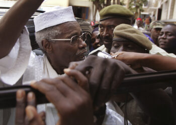 FILE In this Nov. 25, 2005 file photo, former Chad dictator Hissene Habre, left, is seen as he leaves the court in Dakar, Senegal. For more than 20 years, former Chadian dictator Hissene Habre lived a life of luxurious exile in Senegal, taking a second wife and watching 'Seinfeld' shows. But 3,000 miles east of here, a truth commission and rights workers in Chad were documenting widespread abuses during Habres rule, including disappearances, torture and prison cells so cramped that inmates often died for lack of air. On Tuesday, July 2, 2013, judges at a special court in Dakar formally charged Habre with crimes against humanity, war crimes and torture. (AP Photo/Schalk van Zuydam, File)