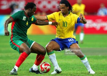 SHENYANG, CHINA - AUGUST 16:  Ronaldinho (R) of Brazil and Andre Bikey of Cameroon compete for the ball during the Men's Quarter Final match between Brazil and Cameroon at Shenyang Olympic Stadium on Day 8 of the Beijing 2008 Olympic Games on August 16, 2008 in Shenyang, China.  (Photo by Koji Watanabe/Getty Images)